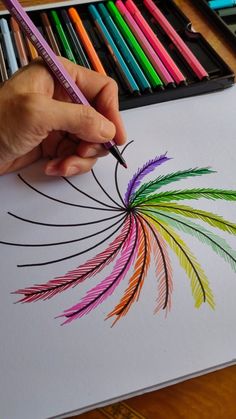 someone is drawing with colored pencils on paper