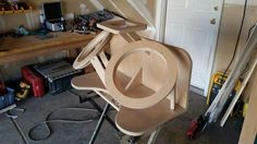 a wooden chair with a hat on top of it in a room full of tools