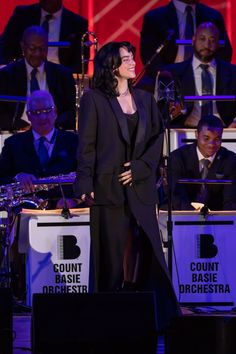 a woman standing on top of a stage next to musical instruments