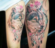 a woman's leg with two wolf tattoos on it