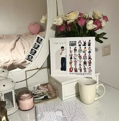 a white dresser topped with lots of drawers next to a mirror and vase filled with flowers