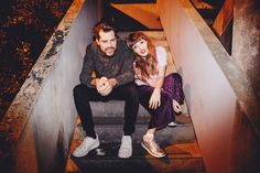 a man and woman sitting on some stairs