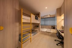 a room with bunk beds, desk and chair in it's side wall area