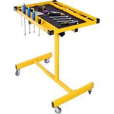 a yellow table with tools on it and some screwdrives in the top drawer