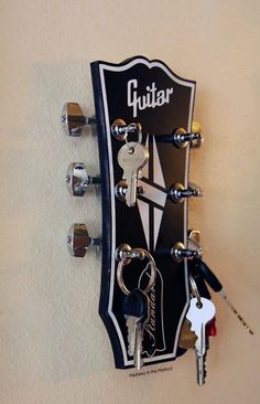 a guitar with keys attached to it hanging on the wall