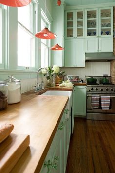 a kitchen with green cabinets and wood floors