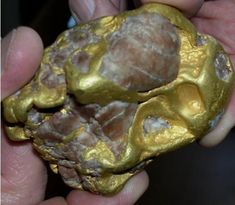 a person holding a gold nugget in their hand