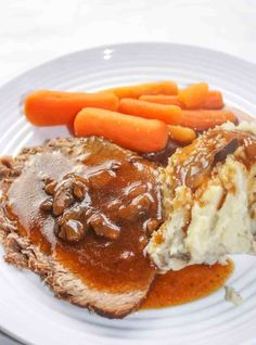 meatloaf with mashed potatoes, carrots and gravy on a plate