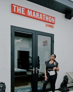 a woman standing in front of the marathon store