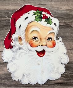 a close up of a santa claus face on a wooden surface