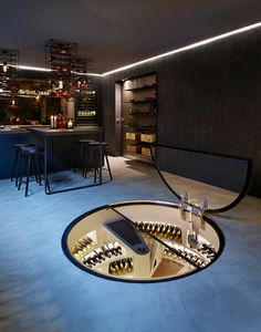 a wine rack in the middle of a room with stools and bottles on it