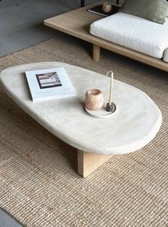 a coffee table with a book and candle on it