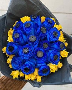 a bouquet of blue and yellow flowers in someone's lapel cover with buttons