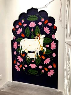 a cow painted on the side of a wall with pink flowers and leaves around it