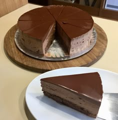 a chocolate cake with one slice missing from it on a plate next to the rest of the cake