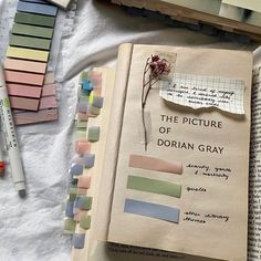 an open book sitting on top of a table next to some markers and pencils