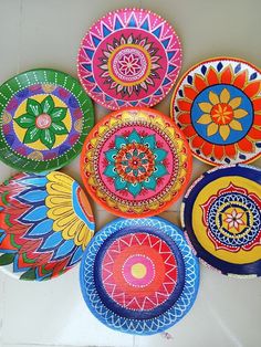 a group of colorful plates sitting on top of a white table next to each other