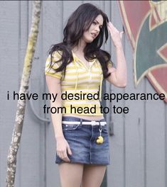 a woman standing in front of a building with her hand up to her ear and the words i have my desired appearance from head to toe