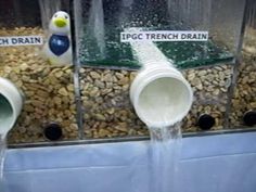 three plastic buckets filled with water on top of rocks