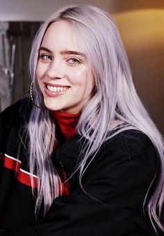 a woman with long white hair smiling at the camera