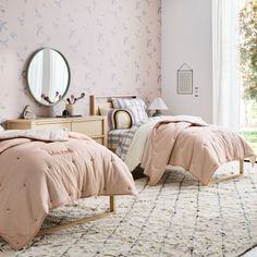 two beds in a bedroom with pink walls