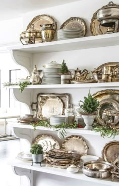 a white shelf filled with lots of plates and silverware on top of each other