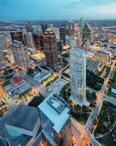 an aerial view of a city at night with skyscrapers and other buildings in the foreground