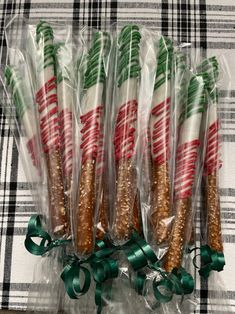 several candy canes wrapped in plastic and tied with green ribbon on a plaid tablecloth