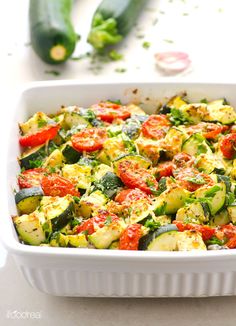 a casserole dish with zucchini, tomatoes and other veggies