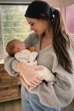 a woman holding a baby in her arms