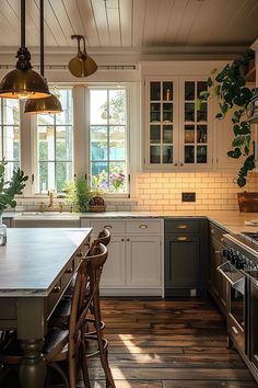 a kitchen with wooden floors and white cabinets, an island countertop and two hanging lights