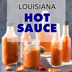 three jars filled with hot sauce sitting on top of a table