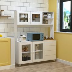 a kitchen with yellow walls and white cupboards filled with food on top of shelves