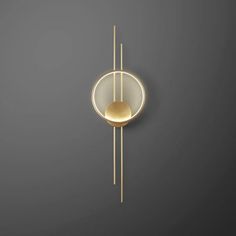 a wall mounted clock on the side of a gray wall with a gold circular design