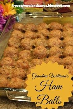 grandma williams'ham balls in a glass baking dish with flowers on the table behind it