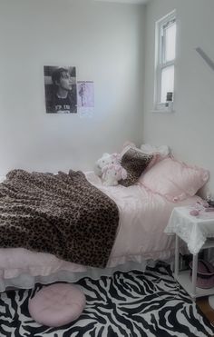 a bedroom with a zebra print rug and pink bedding