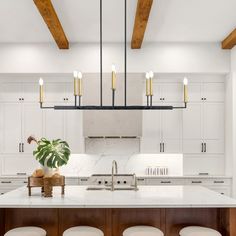 a kitchen island with stools and a potted plant on it in the center