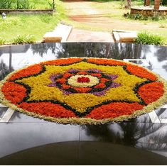 a large flower arrangement on top of a table in the middle of a garden area