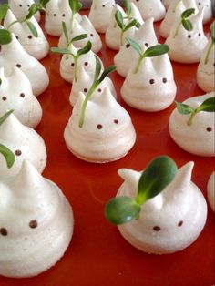 there are many small white cats with green leaves on them, sitting on a red tray