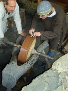 two men working on an object in a factory