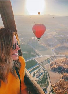 a woman in a hot air balloon looking at the camera