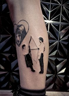 a person with a tattoo on their leg holding a kite and two other people standing next to each other