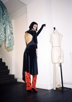 a woman standing next to a mannequin in a room