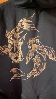 a black hoodie with gold designs on it