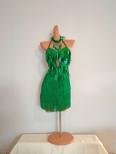 a mannequin wearing a green fringe dress