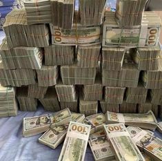 stacks of hundred dollar bills sitting on top of each other in front of a pile of money