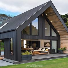 a modern house with an open floor plan and large windows on the front, sitting in grass