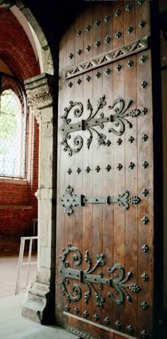 an old wooden door with ornate carvings on it's side and arched doorway in the background