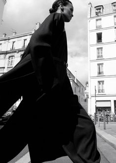 black and white photograph of a man walking down the street