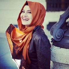 a woman wearing an orange scarf and black jacket